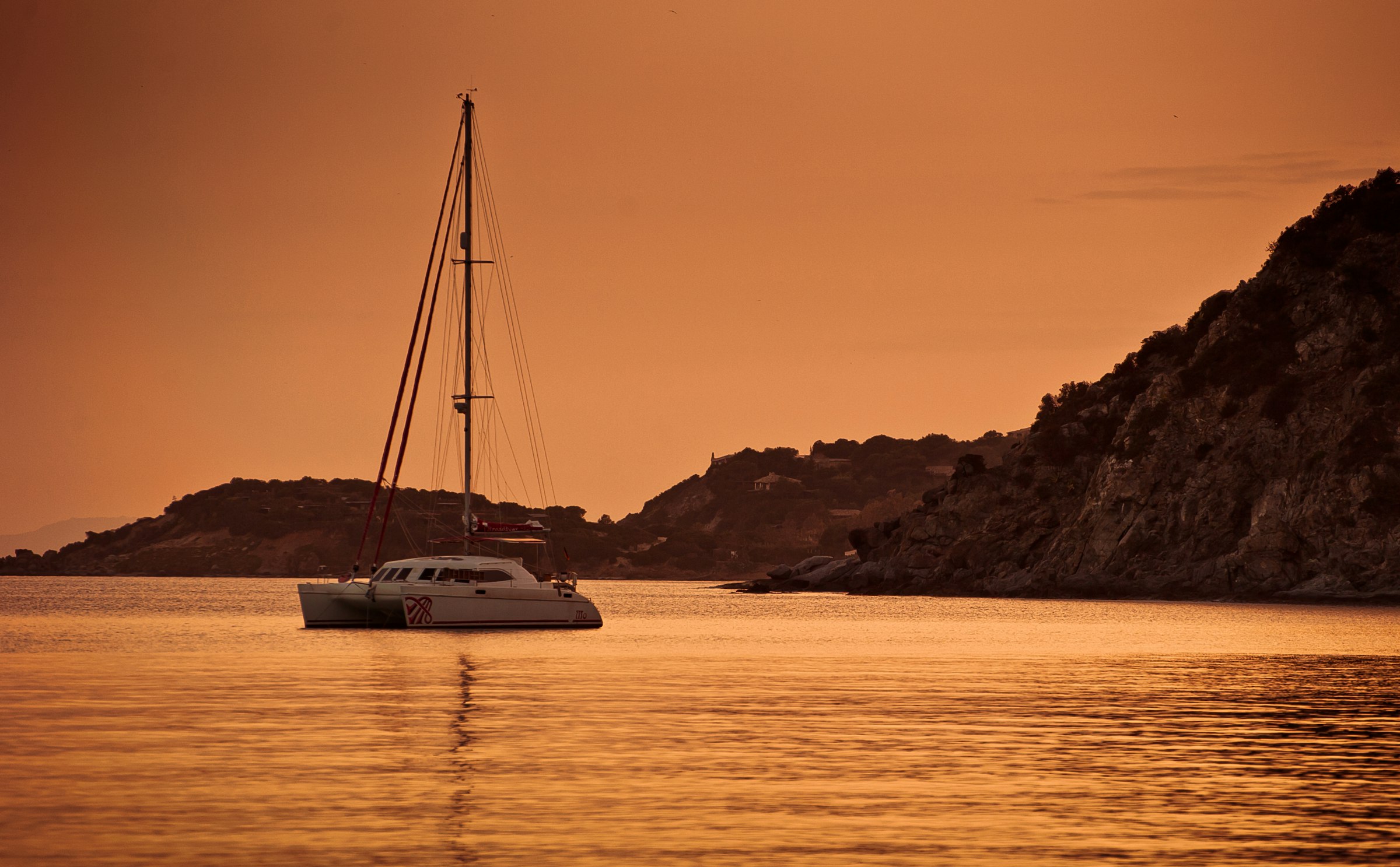 Sailing catamaran at dusk